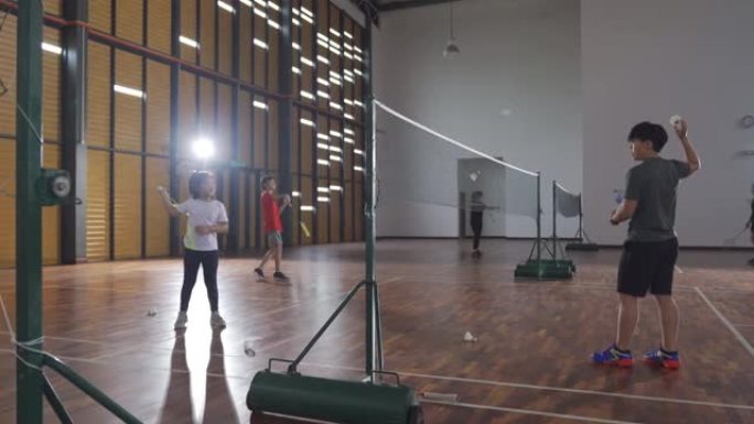 亚洲华裔女子羽毛球教练在羽毛球场教她的学生