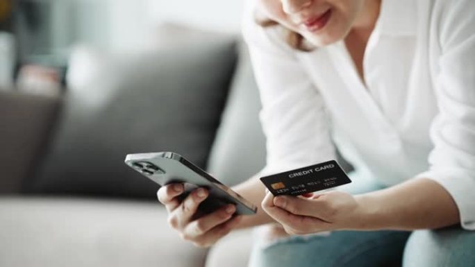 手持信用卡在智能手机上进行在线购物