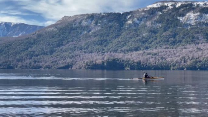 一名男子在阿根廷巴塔哥尼亚圣马丁德洛斯安第斯山脉的拉卡尔湖上划独木舟。4k分辨率。