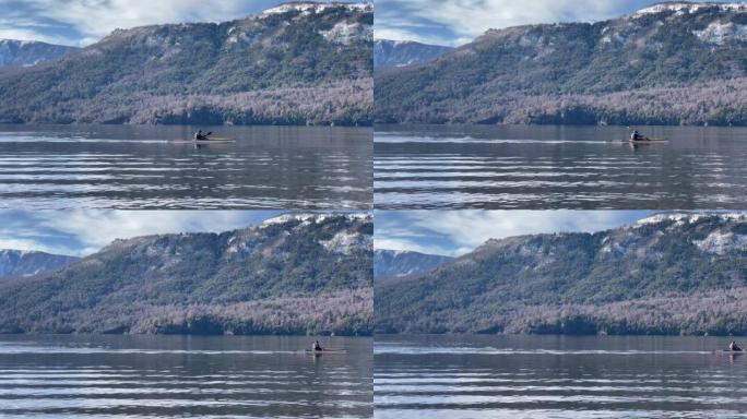 一名男子在阿根廷巴塔哥尼亚圣马丁德洛斯安第斯山脉的拉卡尔湖上划独木舟。4k分辨率。