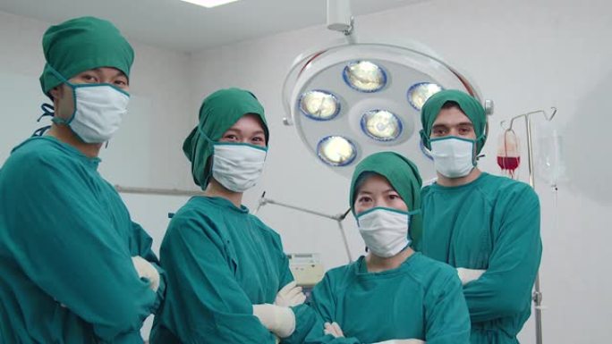 一群头戴口罩、双臂交叉的男女医护人员在手术室里一伙身着医嘱站立，传递着住院的理念。