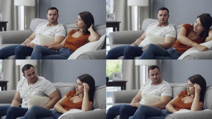4k视频片段，一名妇女与男友坐在家里时看起来不高兴