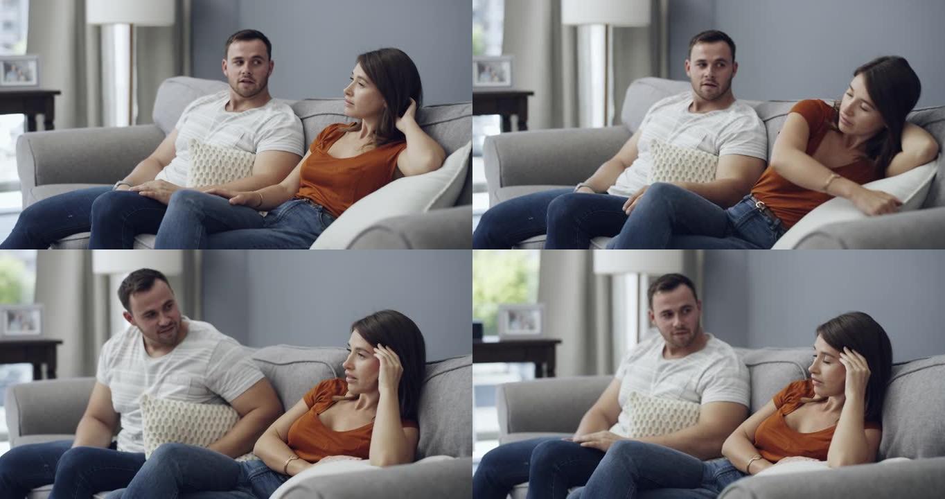 4k视频片段，一名妇女与男友坐在家里时看起来不高兴