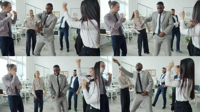 快乐的非裔美国人在工作场所的多种族同事中跳舞
