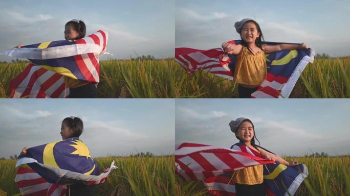 马来西亚独立日一名亚洲华裔年轻女孩在padi球场上裹着马来西亚国旗，享受着早晨的阳光，感到自豪和幸福