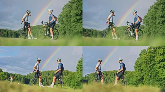 SLO MO两个年轻的骑自行车者看着乡村某个地方的彩虹
