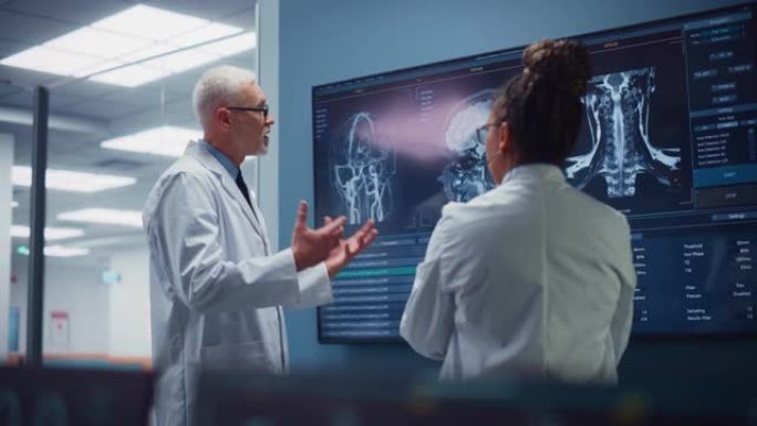 医学神经科学医院实验室会议: 神经外科医生和神经科医生的多元化团队分析电视屏幕显示MRI扫描和大脑图