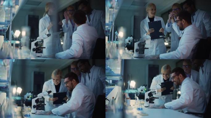令人惊讶的男性研究科学家在显微镜下研究样本时做出了重要发现。快乐的同事击掌并与生物工程师分享成功。