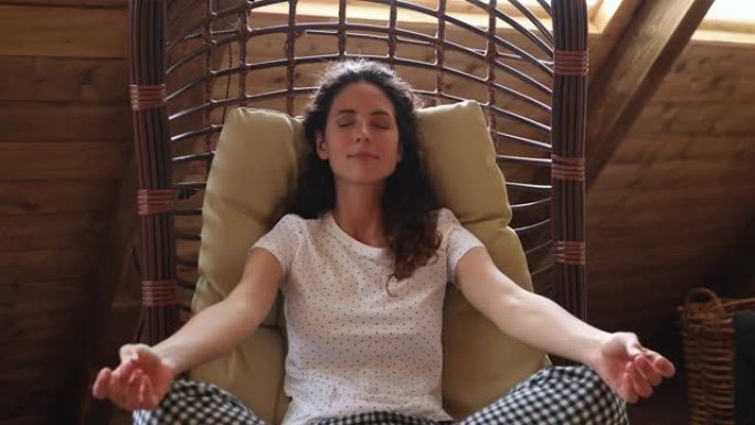 女人做冥想练习坐在秋千吊床躺椅上