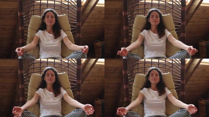 女人做冥想练习坐在秋千吊床躺椅上