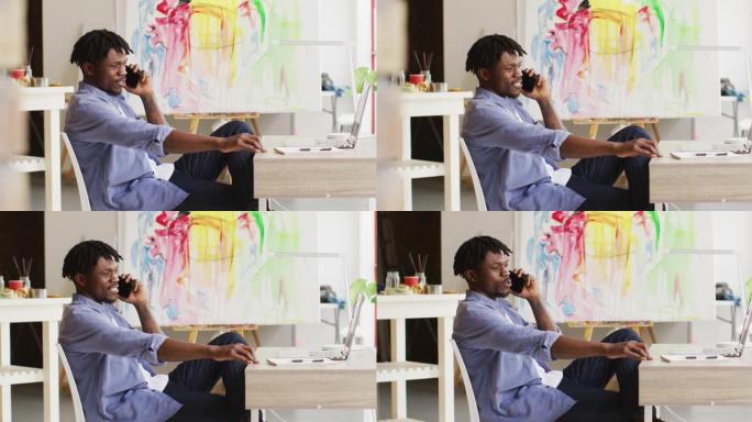 非裔美国男艺术家在art studio的智能手机上聊天
