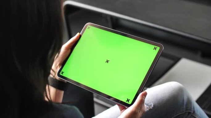女人使用带有绿色屏幕的数字平板电脑