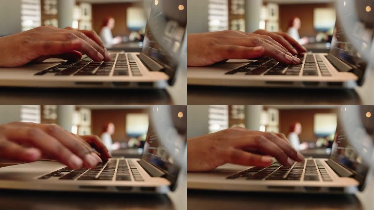 一名坐在餐厅餐桌上的笔记本电脑上工作的妇女的特写镜头