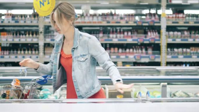 金发女人正在选择在超市买什么