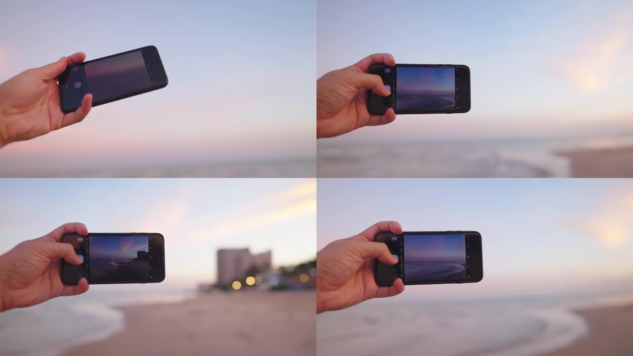 亚洲男子手持智能手机在海滩度假时拍照。