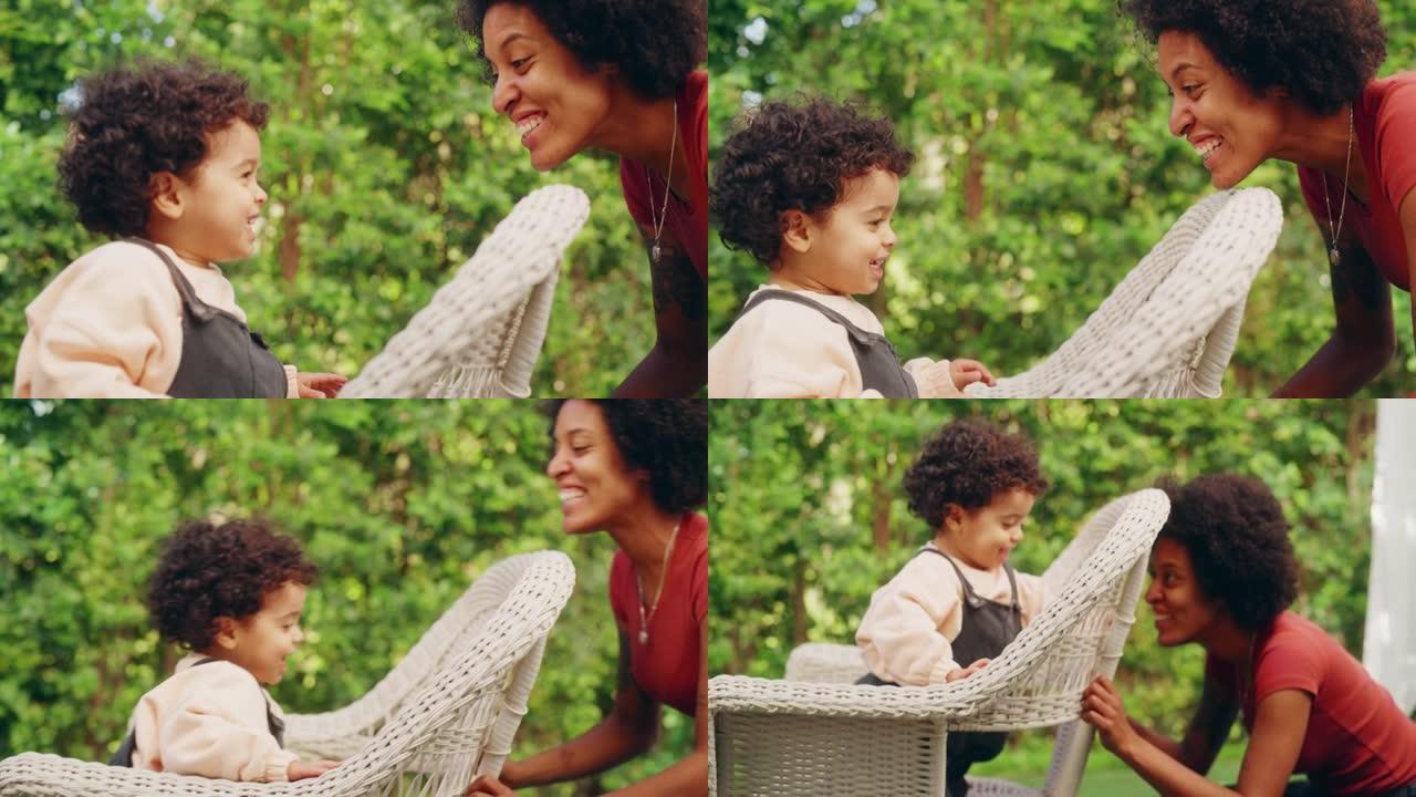 快乐的妈妈和可爱的男婴一起玩，在外面玩得很开心。快乐的拉丁女性躲在花园后面的蹒跚学步的孩子身边。童年