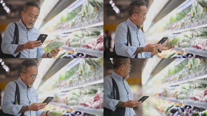 亚洲华人高级男子在蔬菜冷藏区的超市购物