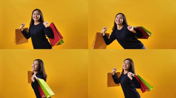 年轻的亚洲妇女背着黄色背景的购物袋