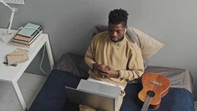 非裔美国人在床上的笔记本电脑上进行网络通话