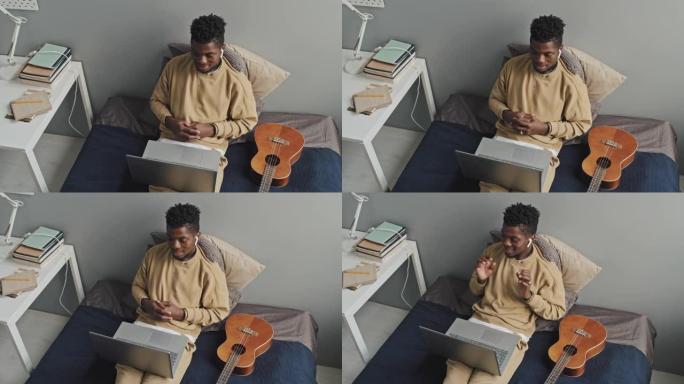 非裔美国人在床上的笔记本电脑上进行网络通话