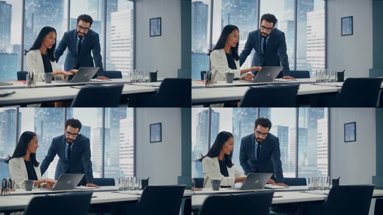 现代办公室: 成功的公司首席执行官坐在办公桌前，在笔记本电脑上工作，并咨询高级经理。微笑的商人讨论对