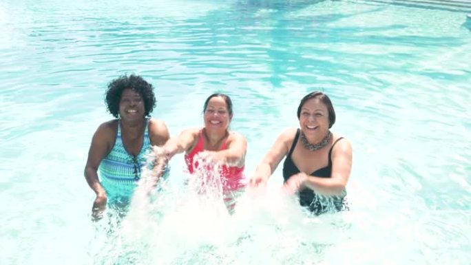 游泳池里的三名高级妇女溅起了相机