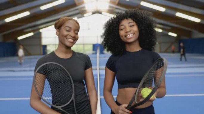 两名年轻的非洲女子网球运动员在硬地球场上的肖像