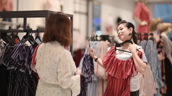 亚洲华人女性在服装店选择衣服