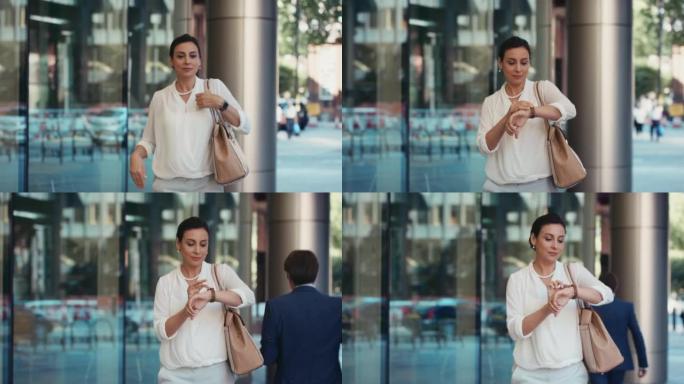 4k视频片段，一名女商人在穿越城市时检查手表
