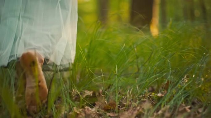 穿着白色长裙的SLO MO女人赤脚走在高高的草丛中