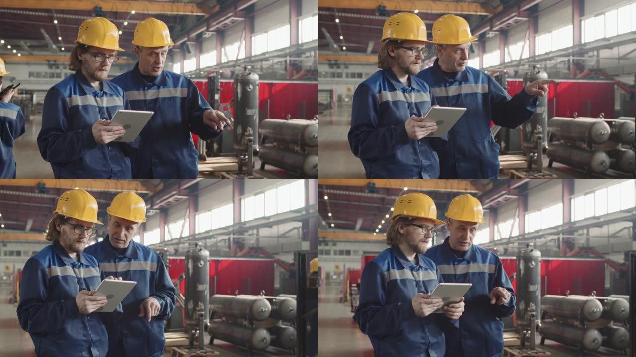 工厂工人与平板电脑在工作场所交谈