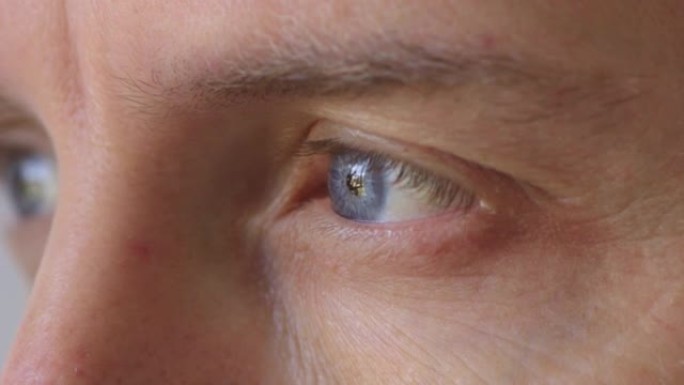 蓝眼睛凝视，眨眼和白日梦的人的特写镜头。面对一个严肃而焦虑的人，在感知世界，思考决策和思考未来时看起