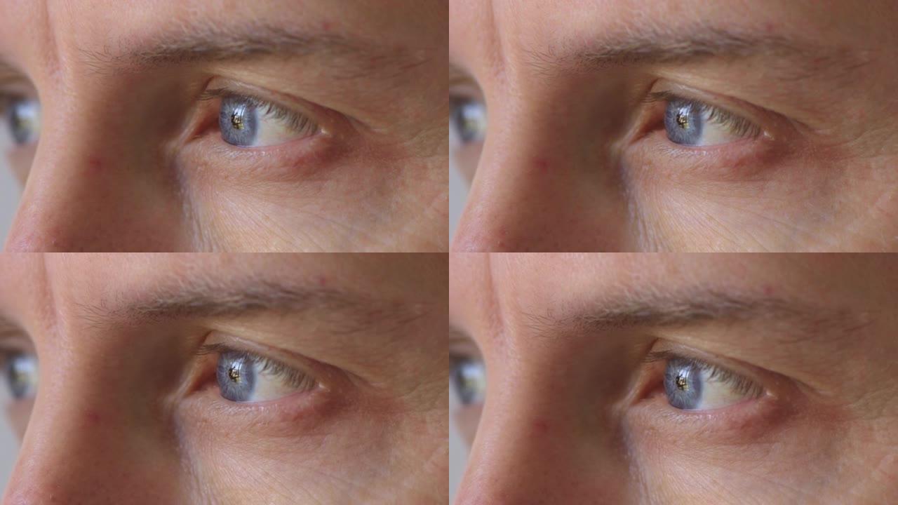 蓝眼睛凝视，眨眼和白日梦的人的特写镜头。面对一个严肃而焦虑的人，在感知世界，思考决策和思考未来时看起