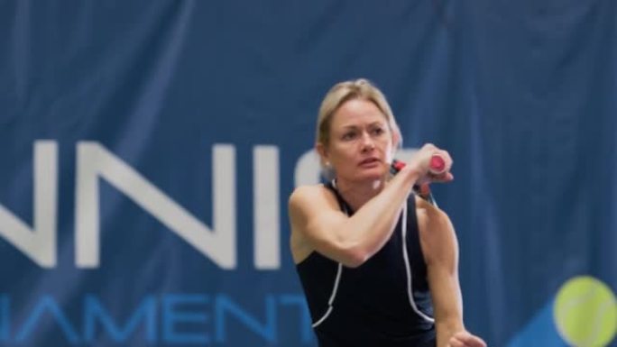 女子网球运动员在锦标赛中用球拍击球。职业女运动员成功接受打击。世界体育比赛。慢动作中景回放