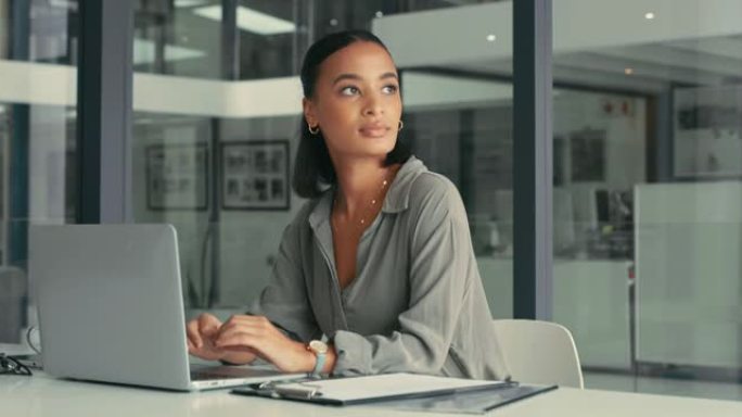 4k视频片段，一位迷人的年轻女商人独自坐在办公室里，在使用笔记本电脑时看起来很沉思