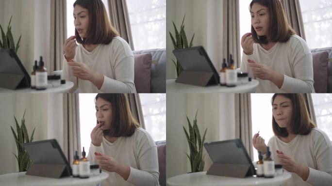 女人在家里的客厅用数字平板电脑学习化妆，独自化妆