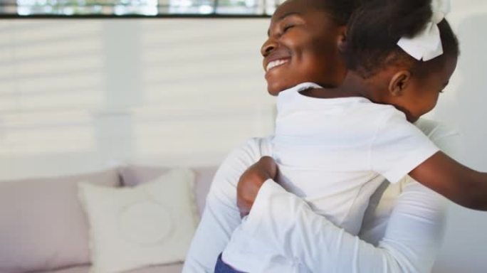 快乐的非洲裔美国母女坐在床上拥抱