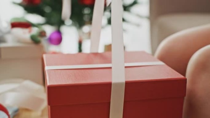 年轻女子为圣诞节包装礼品盒
