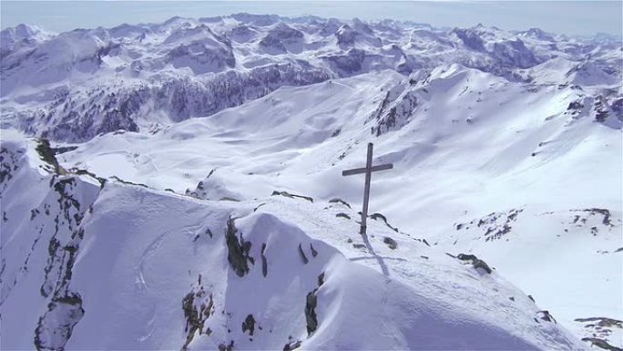 空中: 在雪山顶上的十字架上飞行