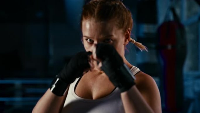 慢动作女拳击手在镜头前摆出格斗姿势