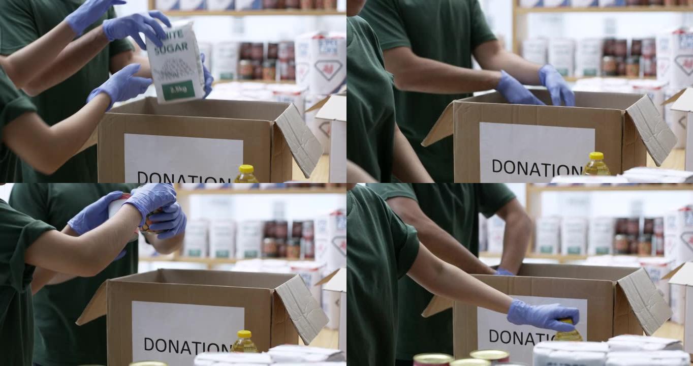 4k视频片段，两个人穿着丁香在捐款箱中包装杂货时穿着丁香