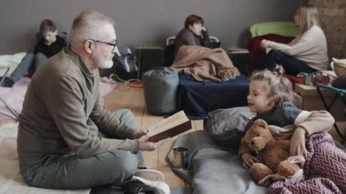 爷爷在逃亡营地给男孩读书
