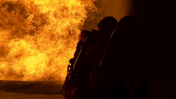 4K UHD消防员使用旋转水雾式灭火器与油中的火焰进行战斗，以控制火势不蔓延。消防员和工业安全概念。