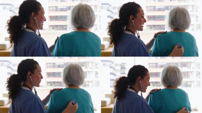 老年医学机构的女护士用一名无法辨认的高级妇女的听诊器检查肺部