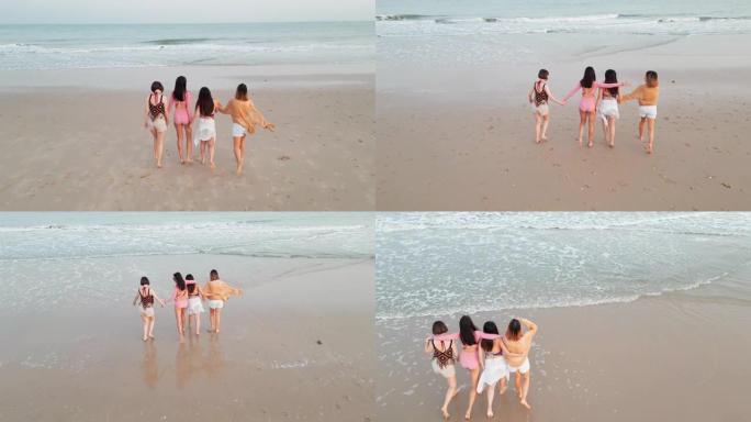 空中无人机的观点亚洲和印度青少年种族妇女在幸福行动中走在一起进入海滨海滩