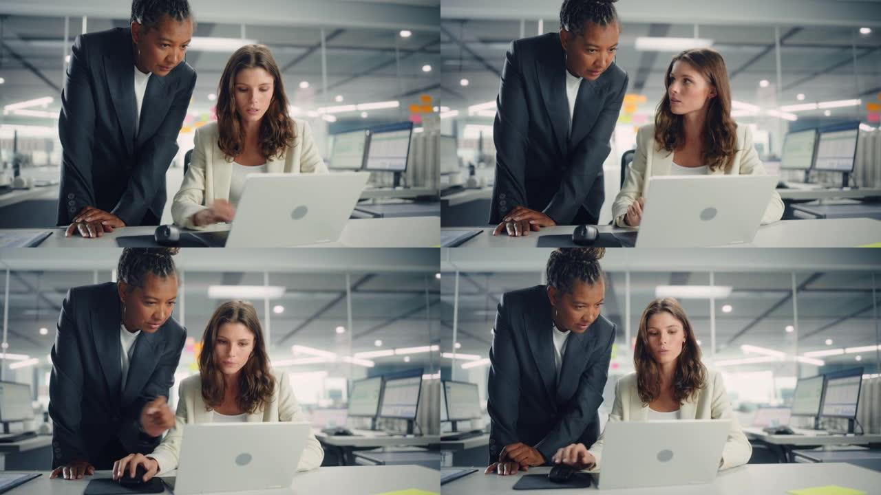 两名女同事深情地讨论工作，微笑着在各种现代商务办公室的笔记本电脑上展示项目。经验丰富的经理和年轻员工