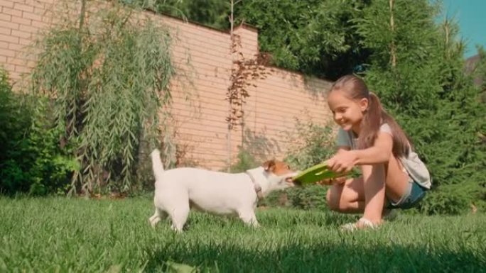快乐的女孩在后院和狗玩耍