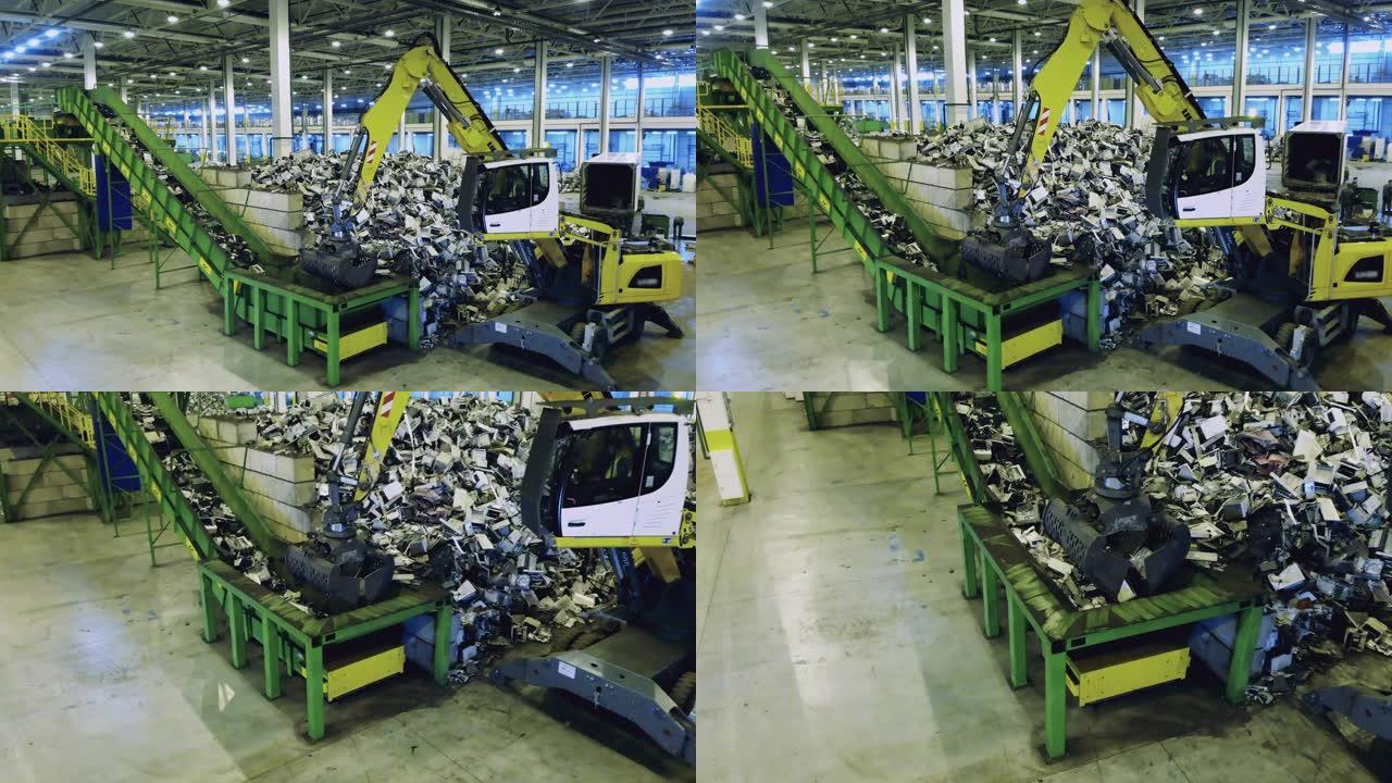 工业机器将垃圾放入工厂的容器中。垃圾回收厂的塑料垃圾。