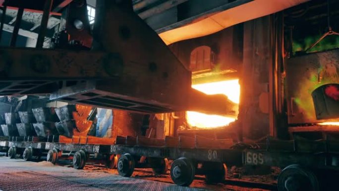 工业机器正在将铜材料装入熔炉中