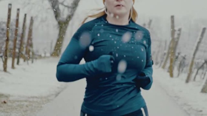 SLO MO女人在开始在雪地里慢跑之前，将入耳式耳机放在耳朵里